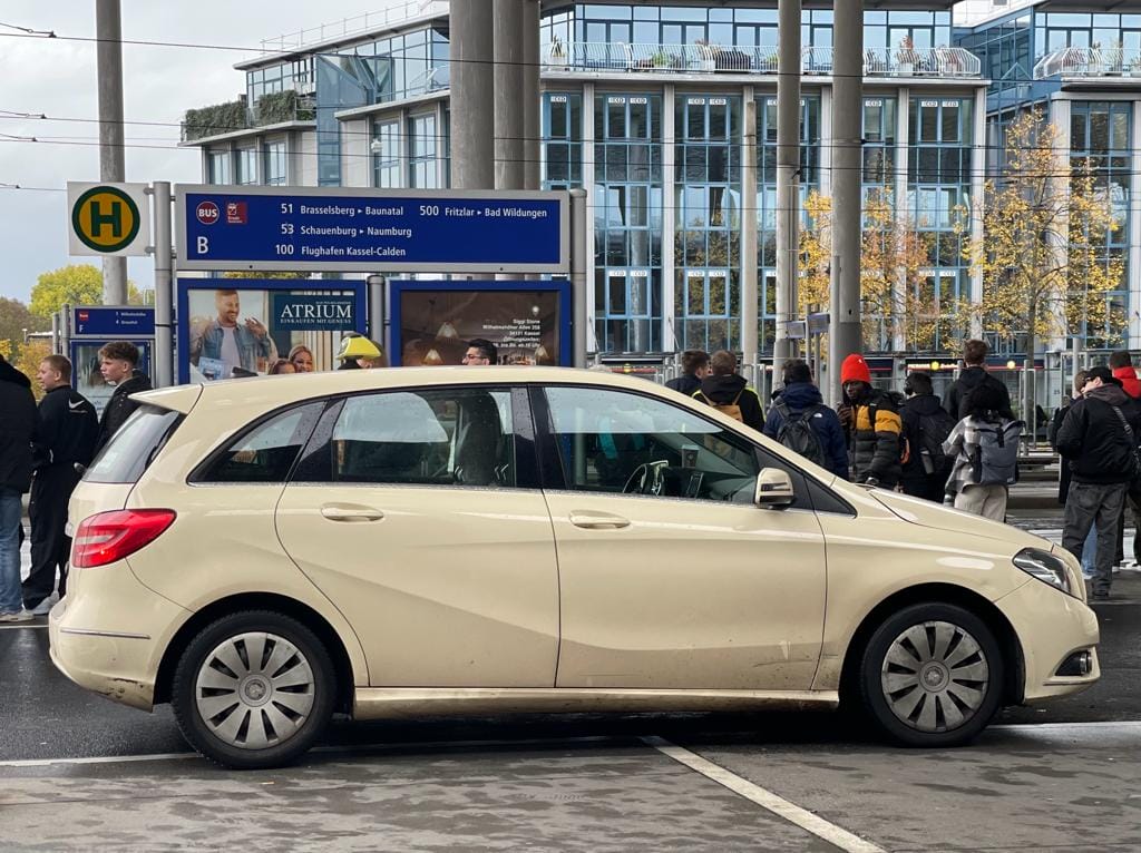A mercedes - benz b-class parked in front of a building.